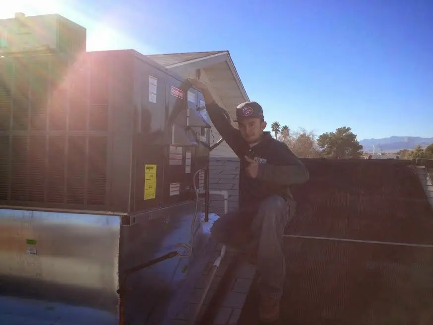 HVAC technician performing Air Duct Repair on a rooftop unit in Scottsdale